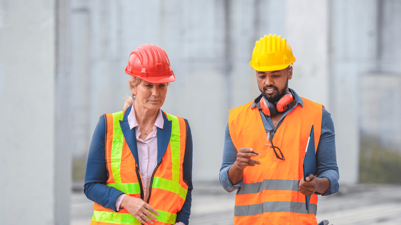 two construction workers wearing safety vests and hard hats