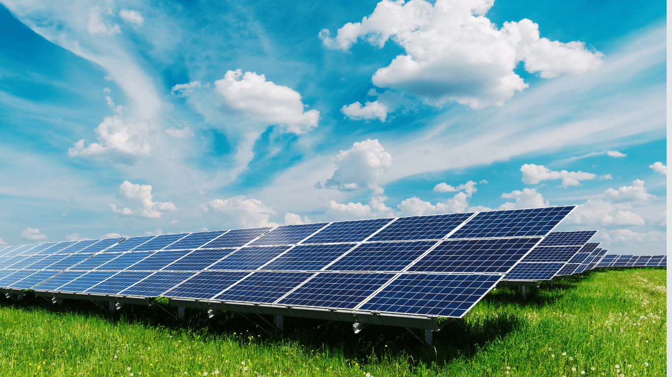 solar panels on a grassy field with blue sky and clouds