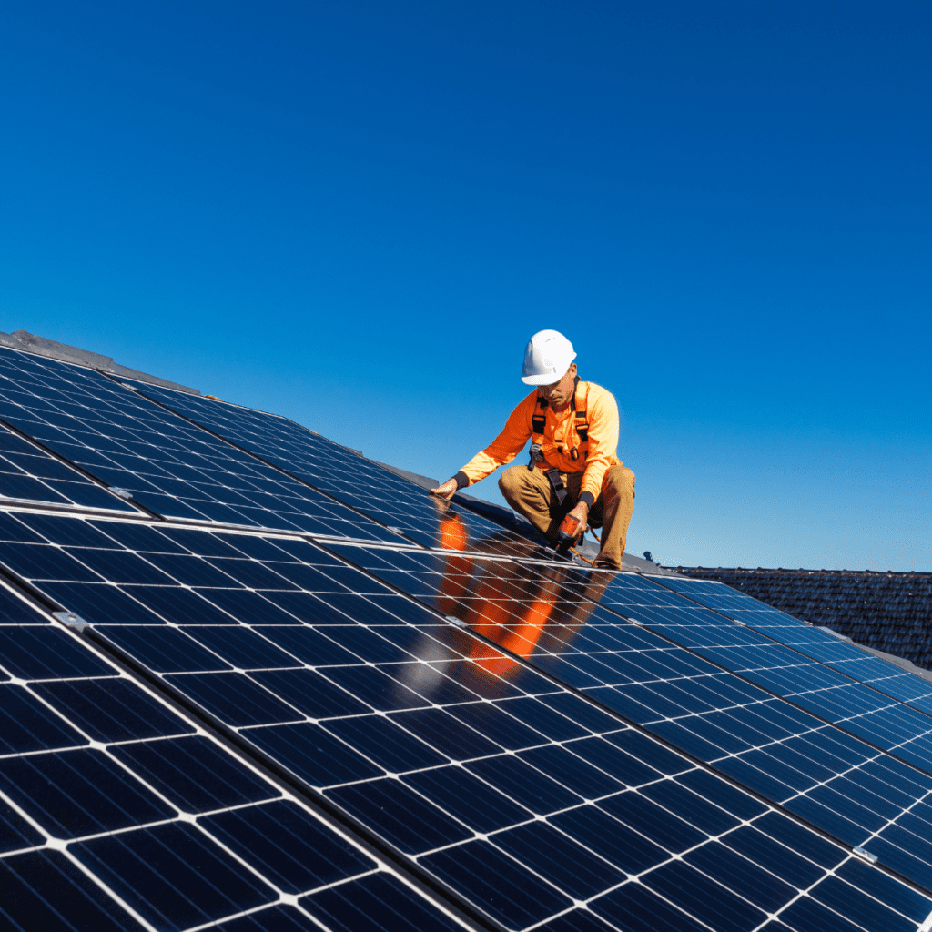 a person working on a solar panel on top of a roof